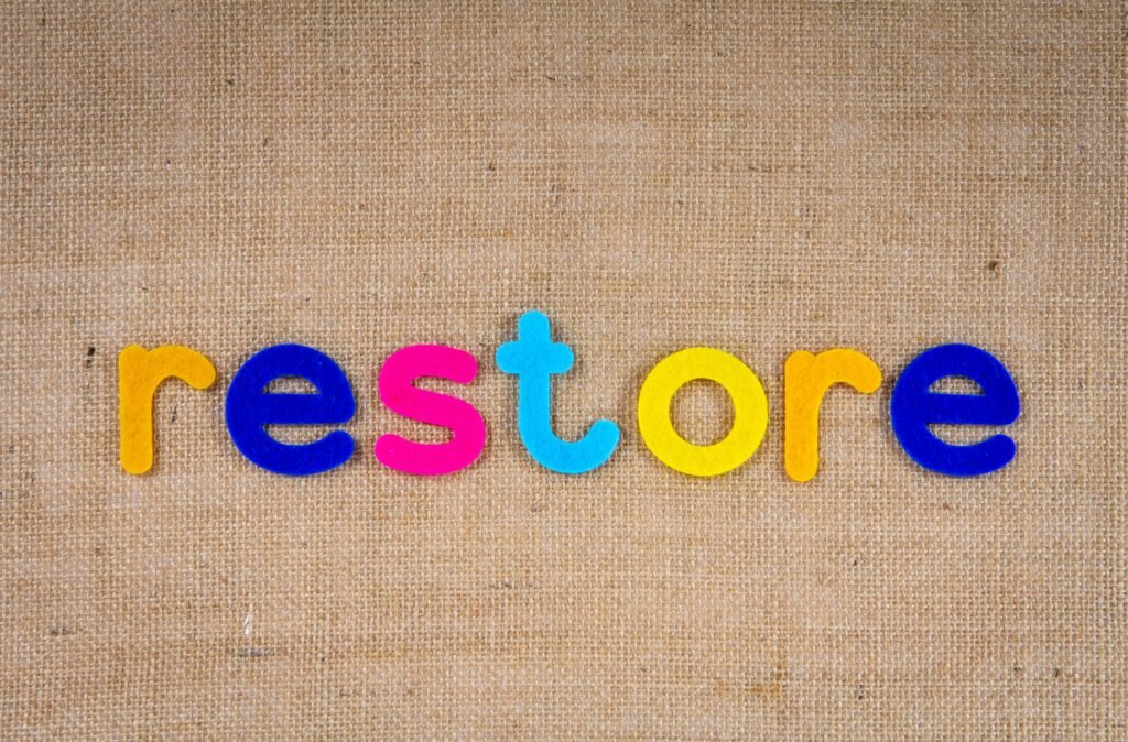 Vibrant colored letters spelling 'restore' on burlap texture, perfect for themes of renewal and recovery.